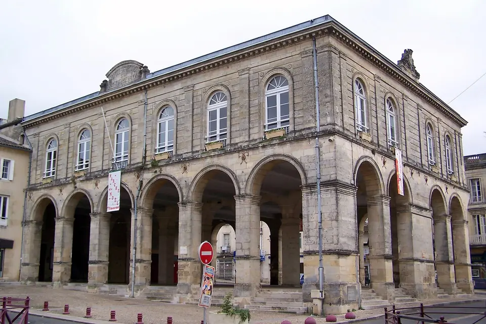 Hôtel de ville de Cadillac-sur-Garonne, bâtiment en pierre de taille à arcades en rez-de-chaussée et fenêtres cintrées à l'étage.